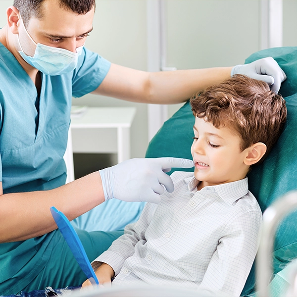 Boy Looking Into Mirror With Dentist
